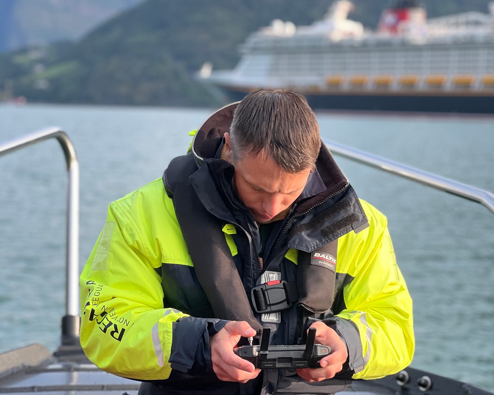 Rando Martinson with the drone controller on the RIB, Disney Dream behind him