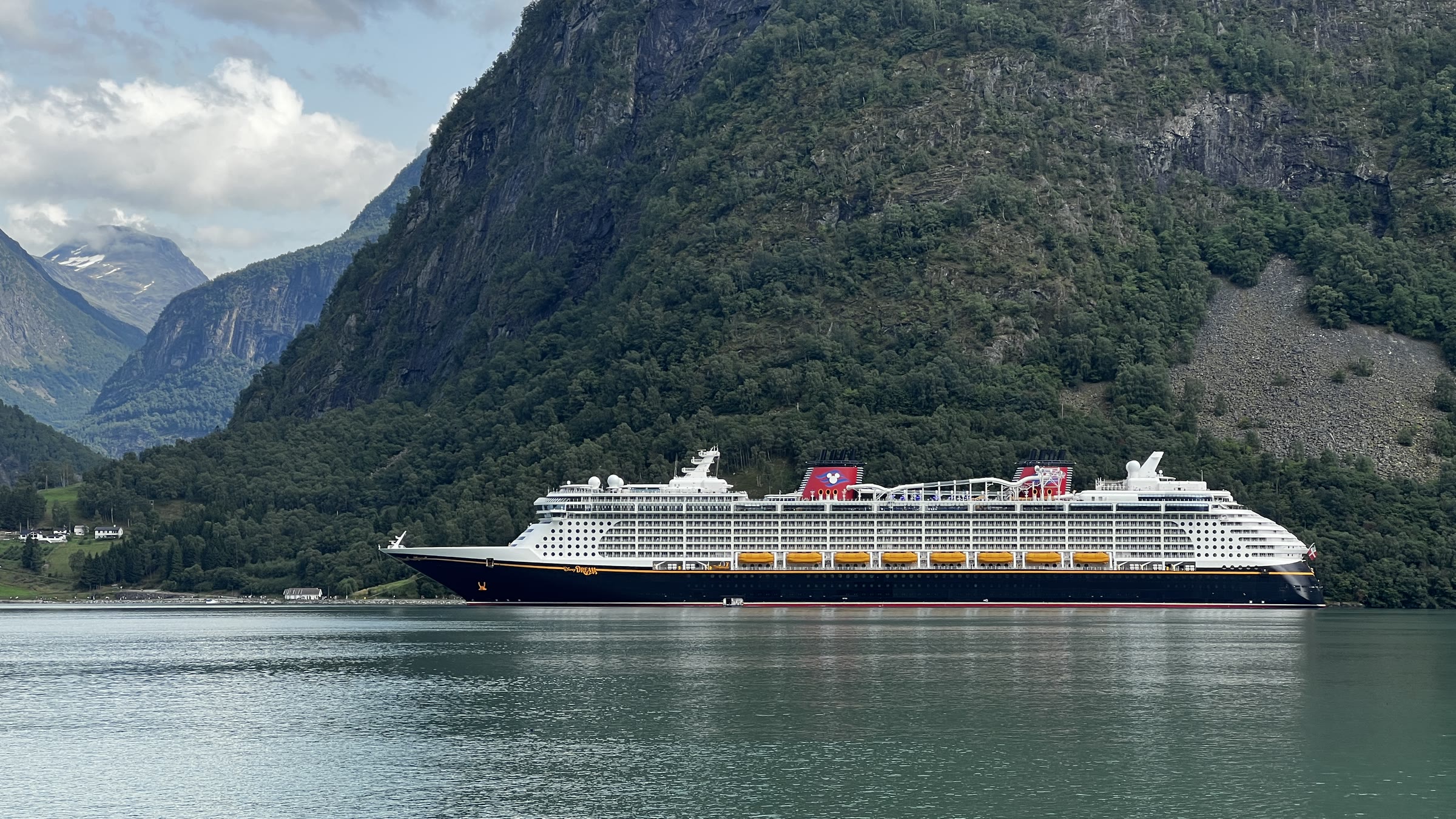 Disney Dream in the fjord beneath steep mountainsides
